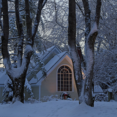 Accent lighting illuminates a rural chapel as day turns into night.