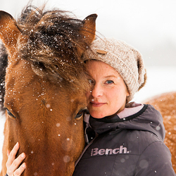 close up of lady and bay pony in snow