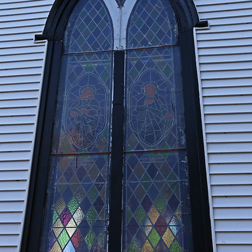 A stained glass window shows it's colors at St. Paul's Anglican Church, Oak Point New Brunswick.