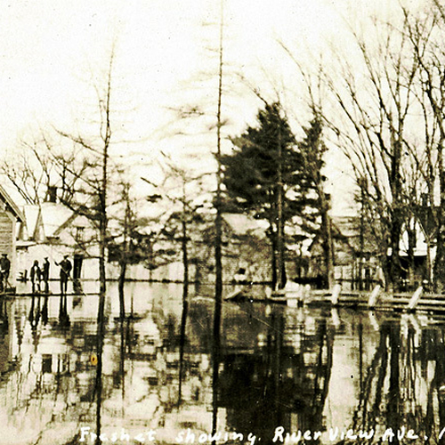 Dated May 11th, 1923 - an image of Riverview Ave. in St. George, NB showing period buildings and men standing on a ma…