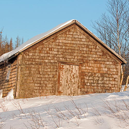 A vintage woodshed or storage barn amid winter conditions in rural Kings County, New Brunswick, Canada.