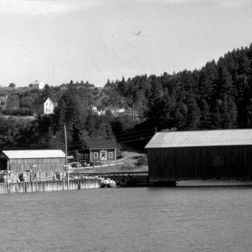 A vintage image of St. Martins Harbour in NB, Canada showing covered bridges and wharf.