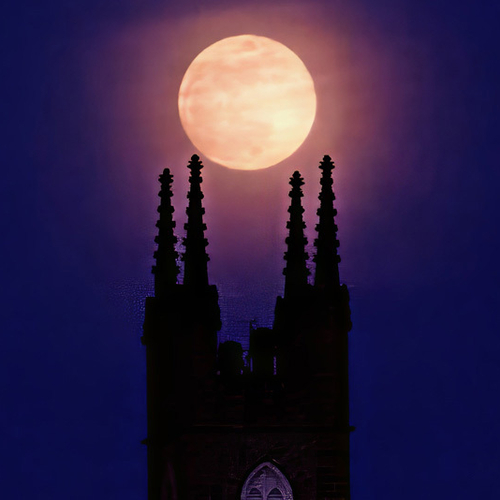 A landscape POV of the historic Stone Church with the full 'Worm Moon' - soon to be eclipsed - rising up behind the s…