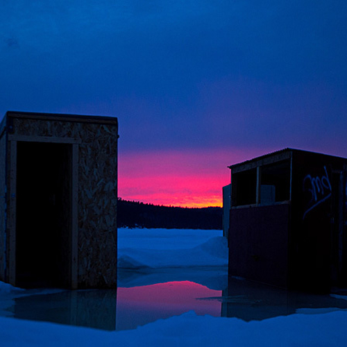 Twilight along the Kennebecasis River @ Rothesay, New Brunswick, Canada with two late season ice shacks silhouetted a…