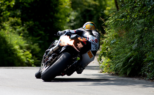 The fans favourite, Guy Martin, on his TAS Suzuki superbike fires off down through The Nook.