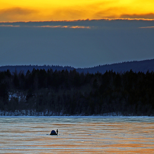 On the last day of winter, a lone hake fisherman stands over his line as the hues of twilight intensify.