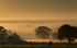 Sunrise over a misty countryside