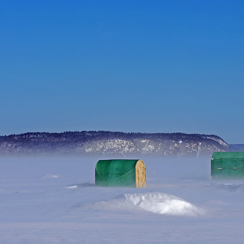 Two ice shacks cope with high winds & drifting snow along the Kennebecasis River near Renforth, New Brunswick.