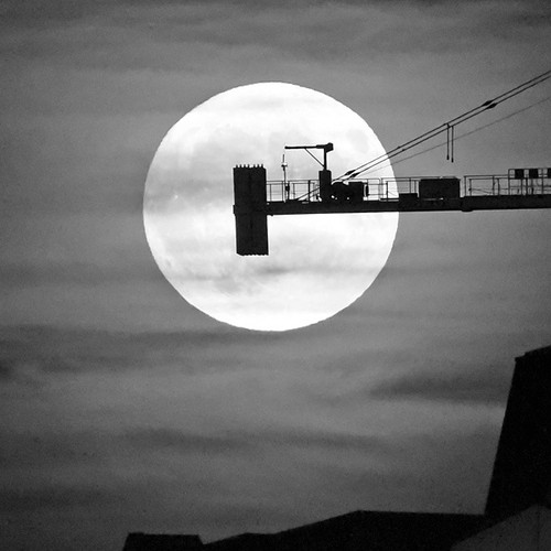 A massive crane in uptown Saint John, New Brunswick is silhouetted by the light of a Super October Moon.