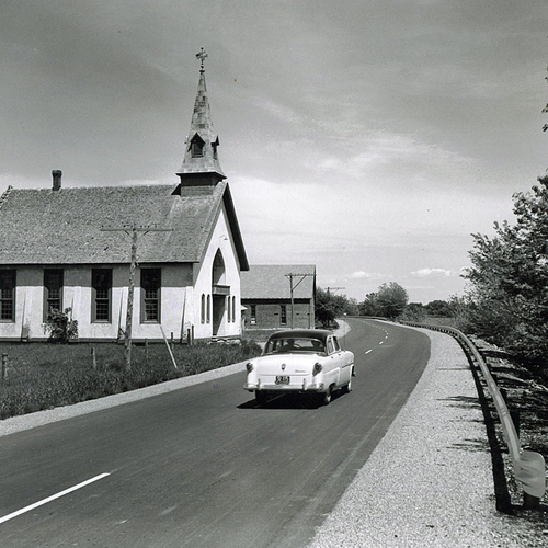 A photo study of a new section of the Trans-Canada Highway taken on July 7th, 1954 and showing a period car passing a…