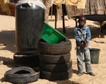 Senegal Fulani Village Fulani boy standing by tyres