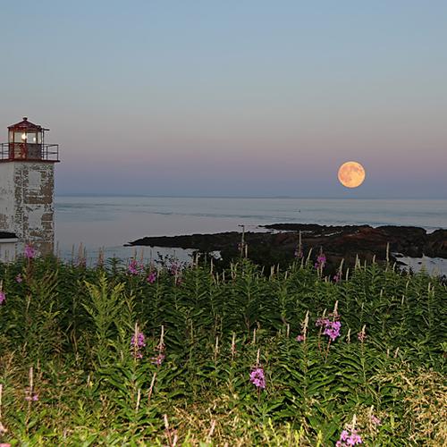The August Supermoon rises over the Bay of Fundy at Quaco Head Lighthouse in Saint John County, New Brunswick, Canada…