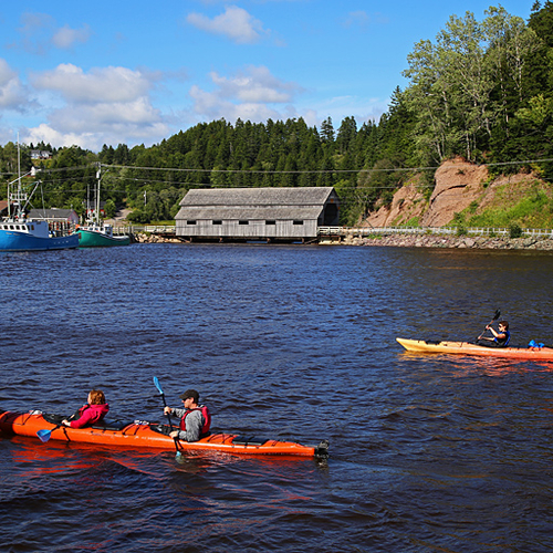 Fishing vessels and a covered wooden bridge greet sea kayakers near the wharf at St. Martins, New Brunswick, Canada.