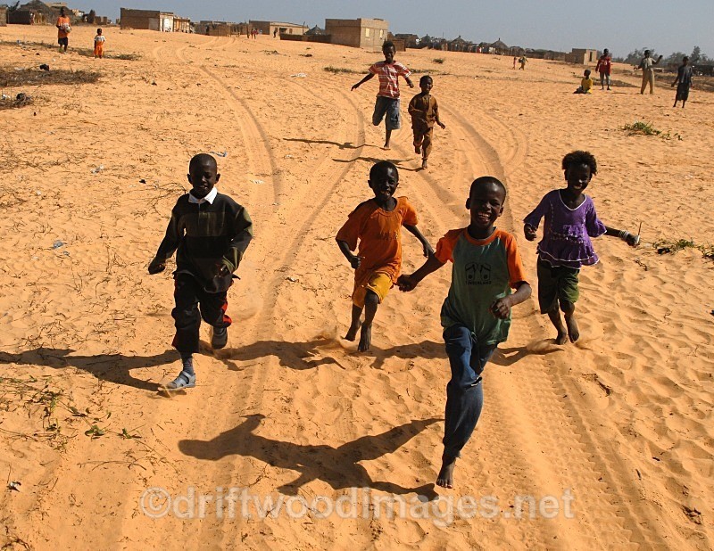 Senegal Fulani Village Fulani children running behind 4x4 - Senegal Fulani Village