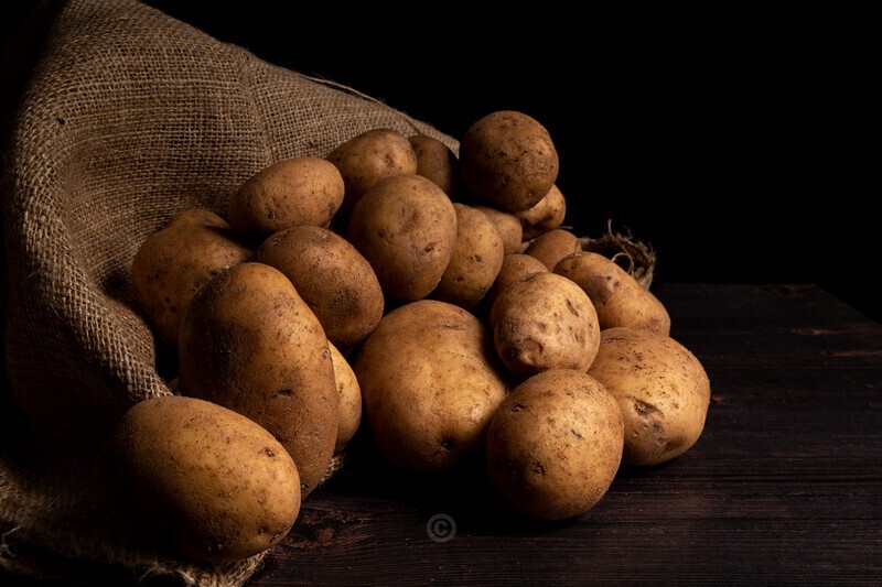 Potatoes and sack on black background - Food Photography