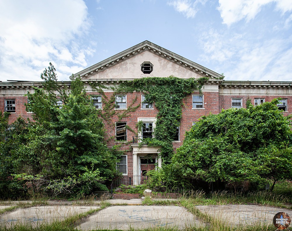 The overgrown facade of the abandoned hospital at Forest Haven