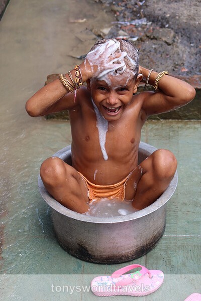Young boy takes a bath on a footpath Kolkota, India - Children