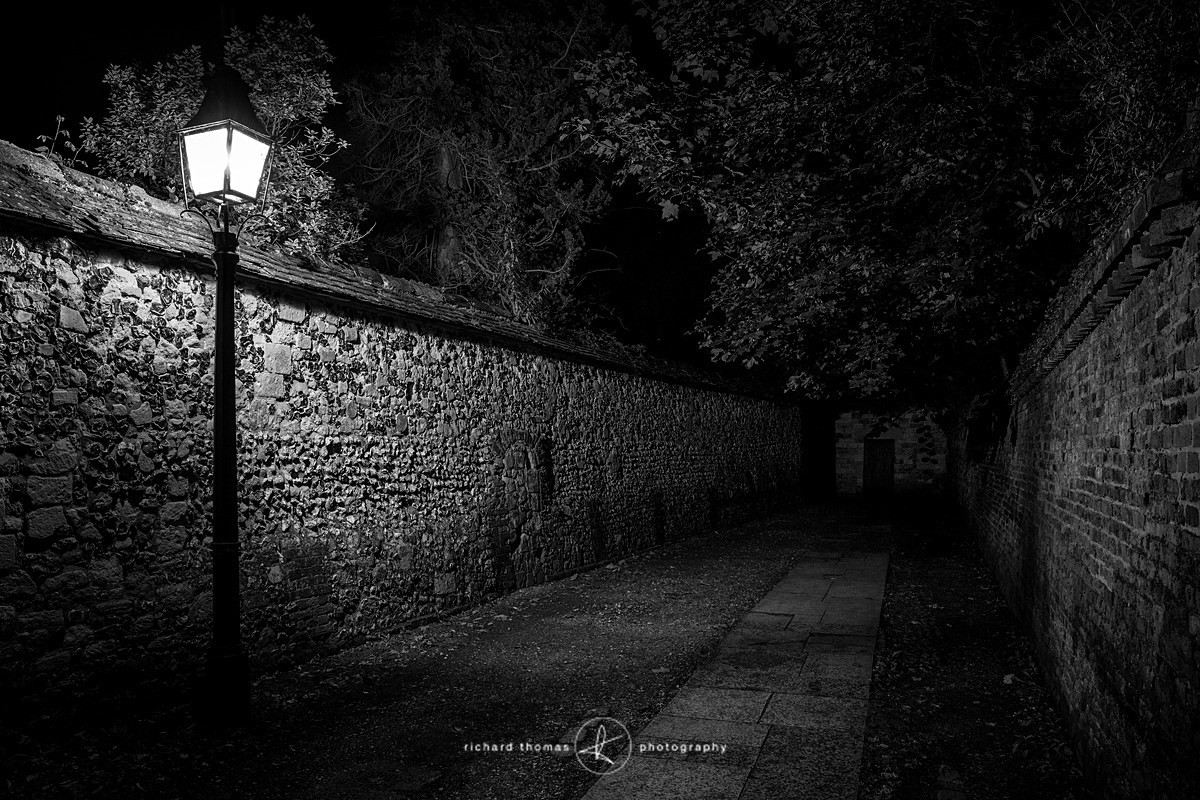 A footpath leading to Winchester Cathedral with street lamp at night