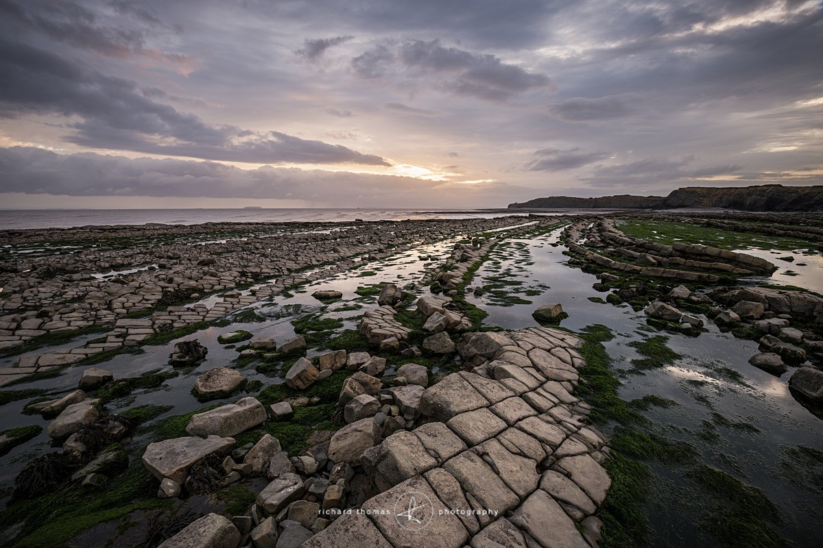 Kilve Pill in Somerset looking across the limestone rock ledges on the beach