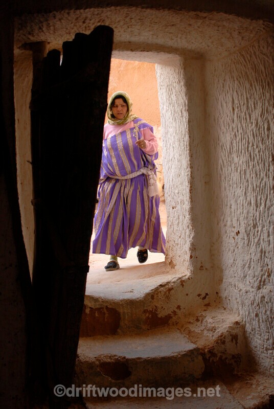 Matmata troglodyte house storeroom woman by door - Tunisia