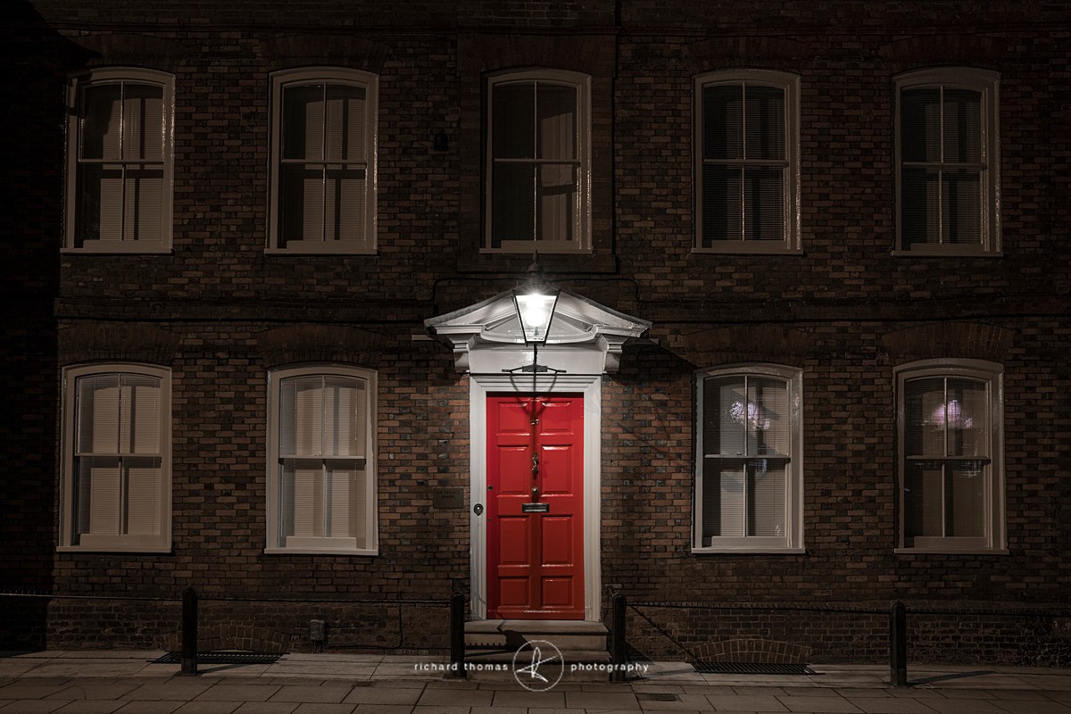 Building with a red door in Winchester at night