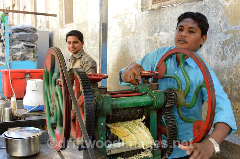 India Porbandar boys with sugar cane squeezer - India