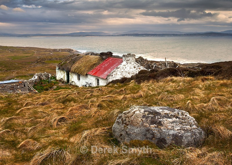 Old Irish Thatched Cottage on the hill overlooking the bay