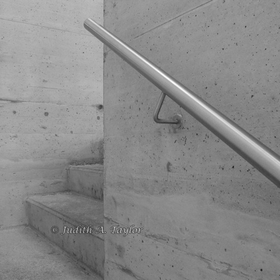 Glimpse of a concrete staircase with metal handrail