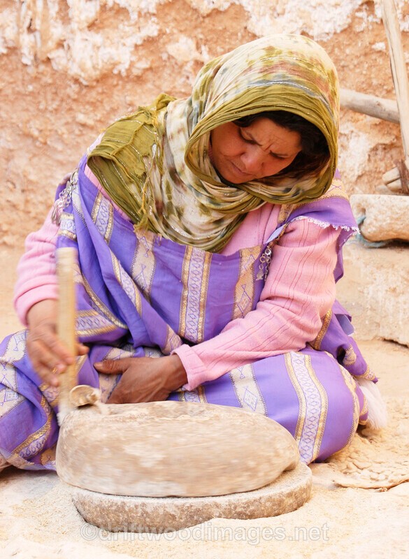 Matmata troglodyte house woman grinding wheat - Tunisia