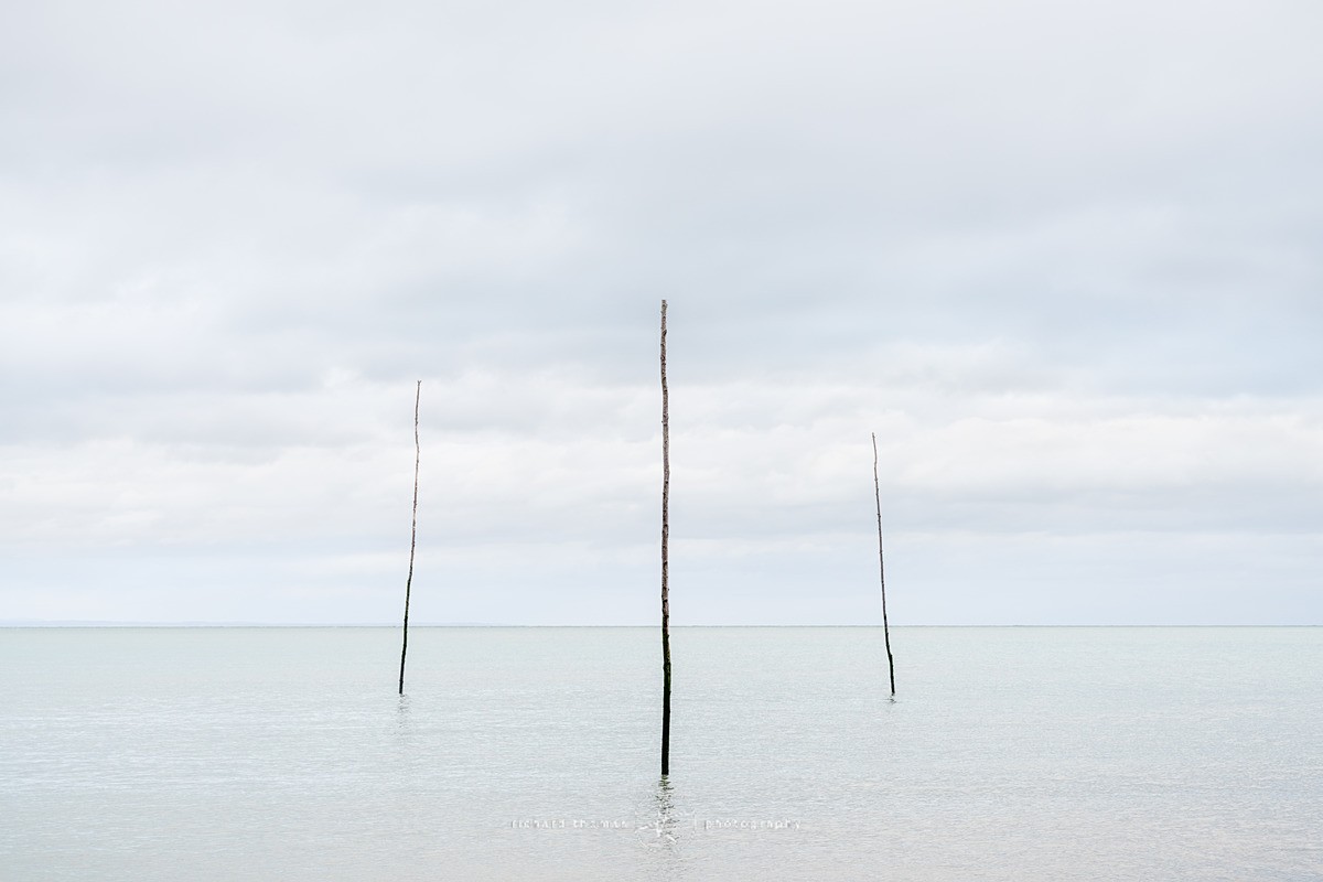 Three harbour marker posts - Minimalist seascape photography