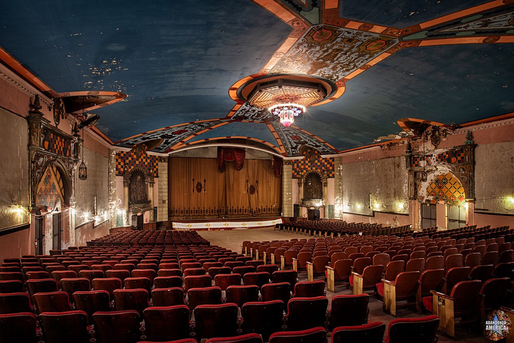Wide interior view of a red, blue, and gold theater auditorium