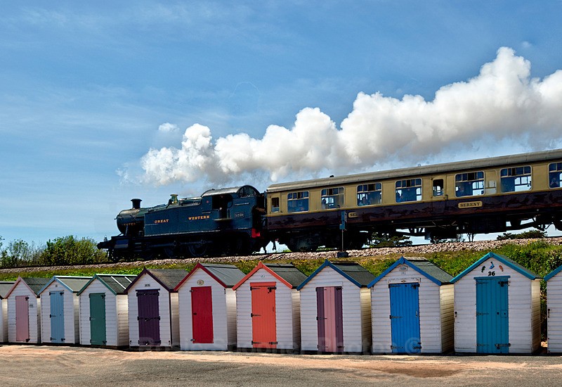 Steam train passing over the beach huts at Goodrington in Torbay