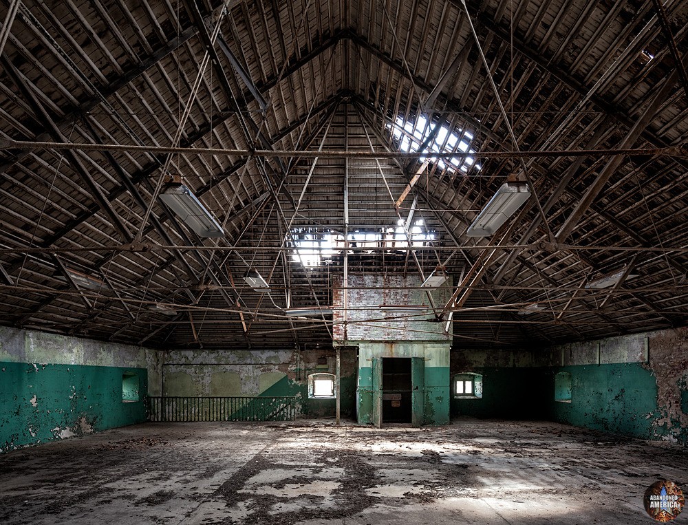 A large empty room with holes in the roof
