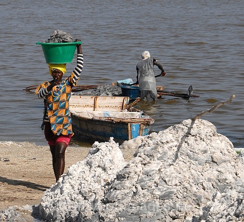 Senegal Lac Rose salt production 9 woman carrying salt from boat to sh - Senegal Salt Production at Lac Rose