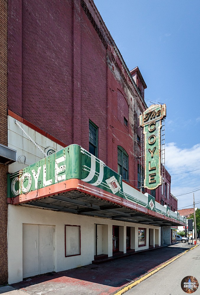 The entrance to a red brick theater; the marquee blade reads 'The Coyle'