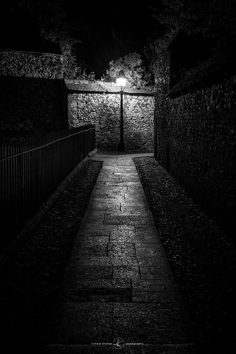 Footpath at the rear of Winchester cathedral lit up at night